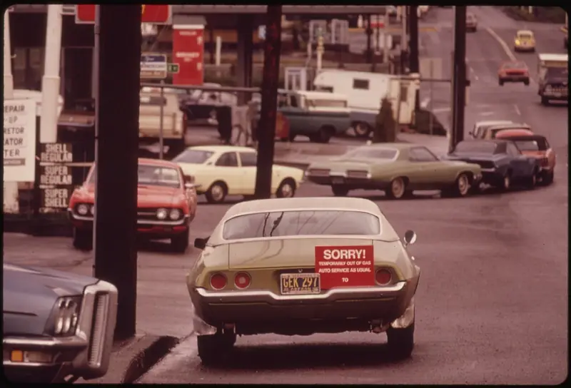 Color photograph of cars lined up at a Portland gas station, the last car carrying a "Sorry" sign to show the station had run out.
